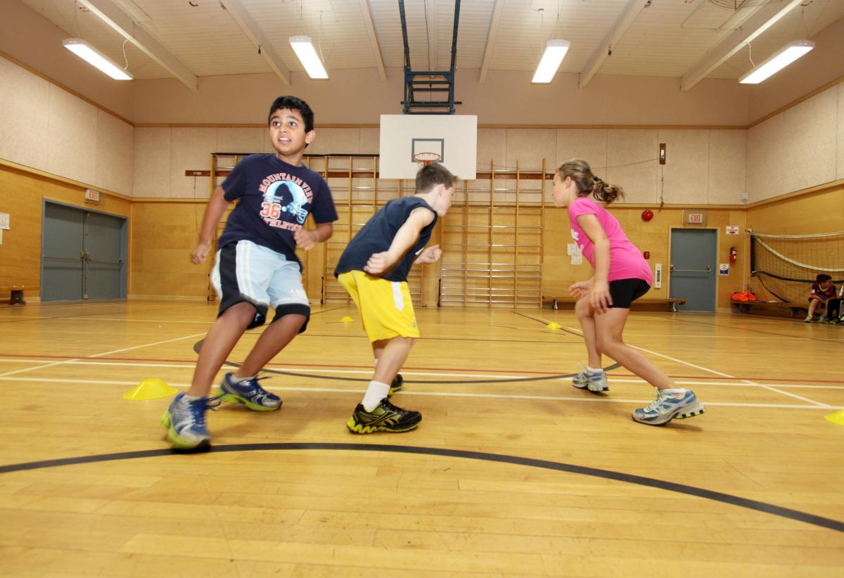 three young children turning 180 degrees before the continue running