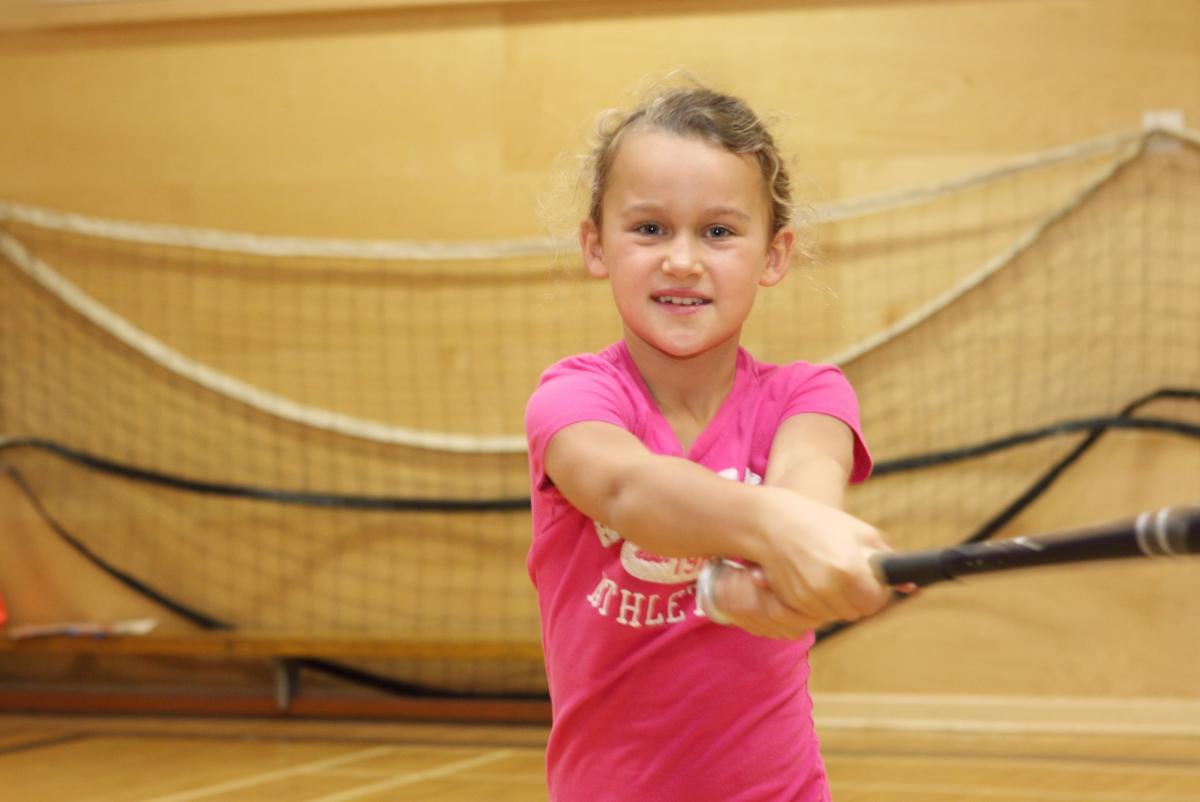 young girl swinging a baseball bat