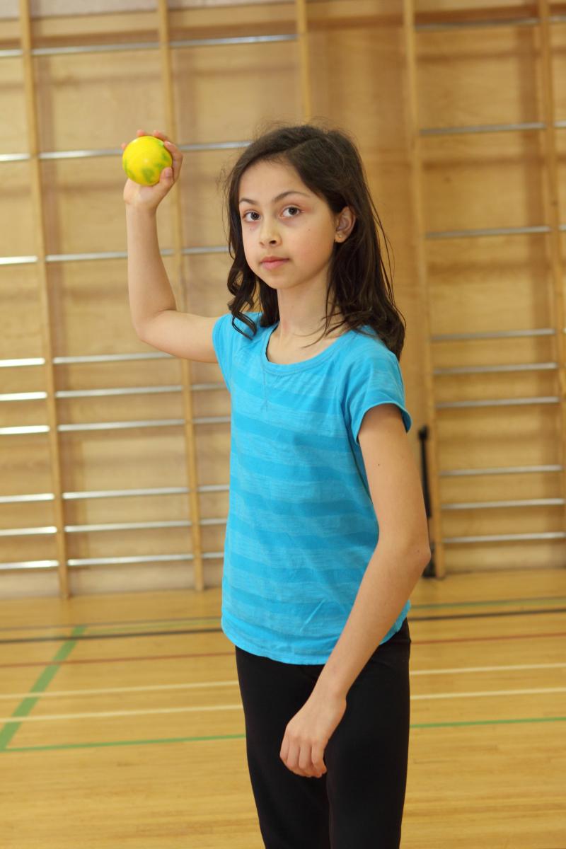 Young girl holding ball in throwing position